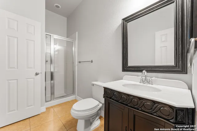 a bathroom with a sink a toilet a mirror and shower