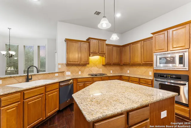 a kitchen with stainless steel appliances granite countertop stove microwave and refrigerator