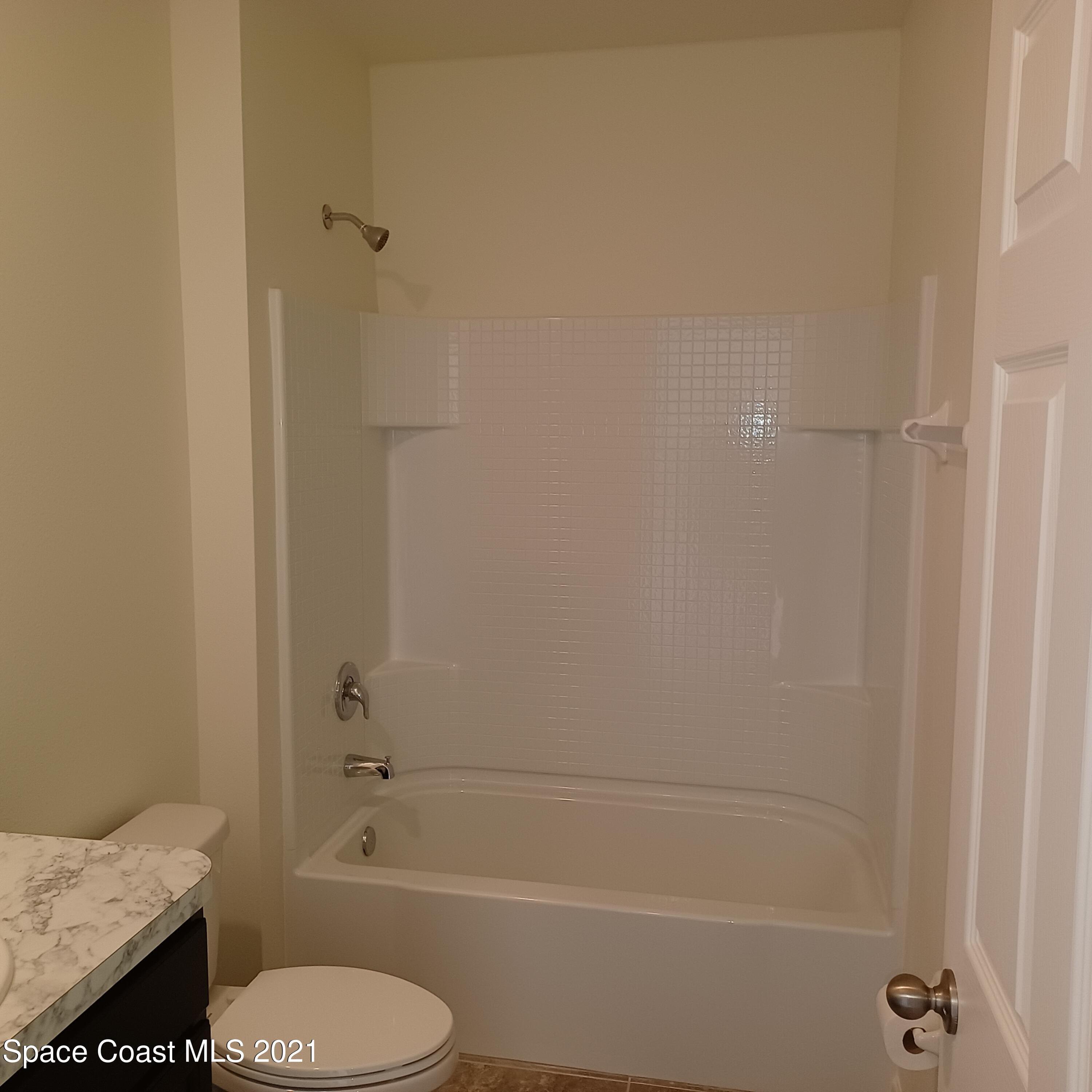 6558 Marble Road Cocoa, FL 32927 - Photo 6 of 16 a bathroom with a granite countertop toilet and a sink