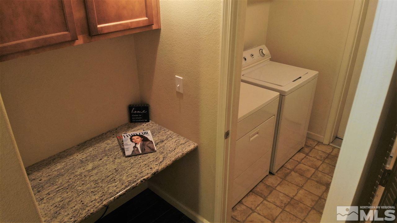 9050 Double R Boulevard, Unit 1612 Reno, NV 89521 - Photo 14 of 25 a bathroom with a granite countertop sink and a washer