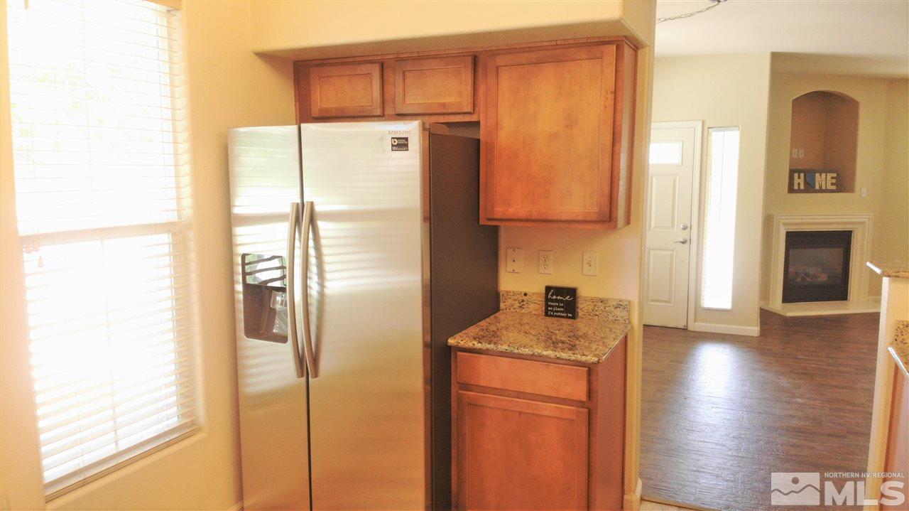 9050 Double R Boulevard, Unit 1612 Reno, NV 89521 - Photo 3 of 25 a kitchen with stainless steel appliances granite countertop a refrigerator a stove and a sink with wooden floor