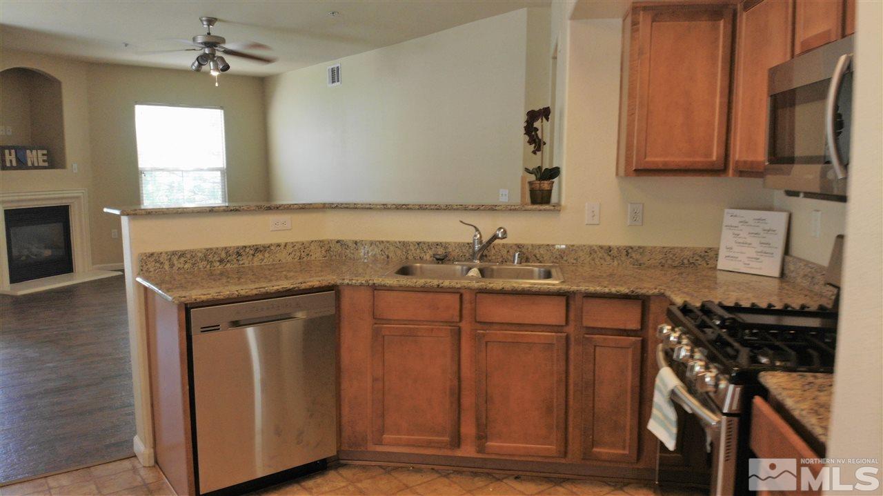 9050 Double R Boulevard, Unit 1612 Reno, NV 89521 - Photo 4 of 25 a kitchen with stainless steel appliances granite countertop a sink stove and cabinets