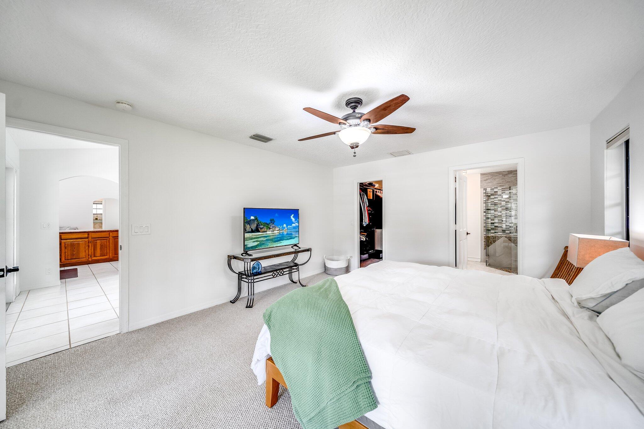 9268 Rodeo Drive Lake Worth, FL 33467 - Photo 19 of 66 a bedroom with a bed and a chandelier