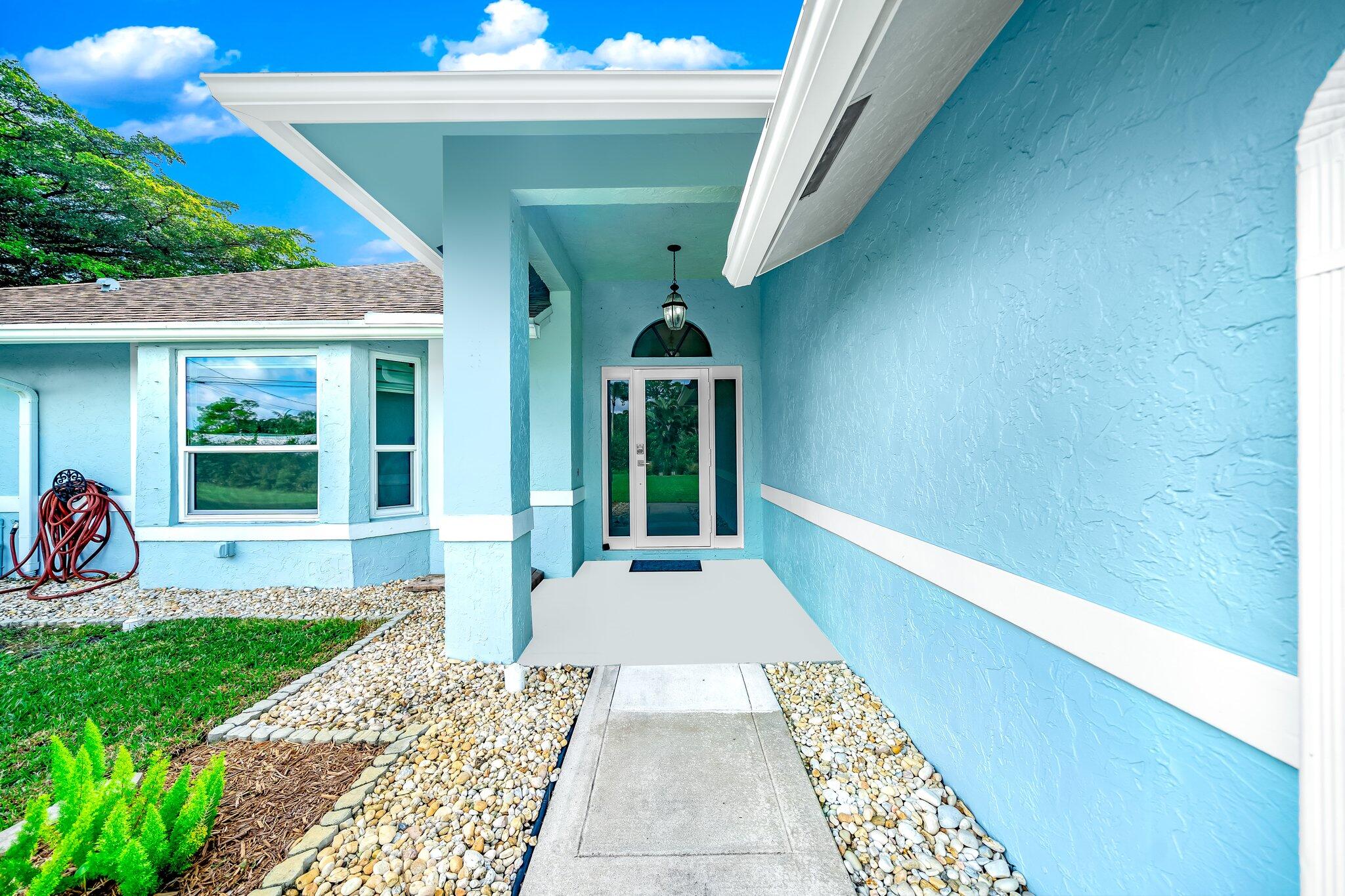 9268 Rodeo Drive Lake Worth, FL 33467 - Photo 3 of 66 a front view of a house with a yard