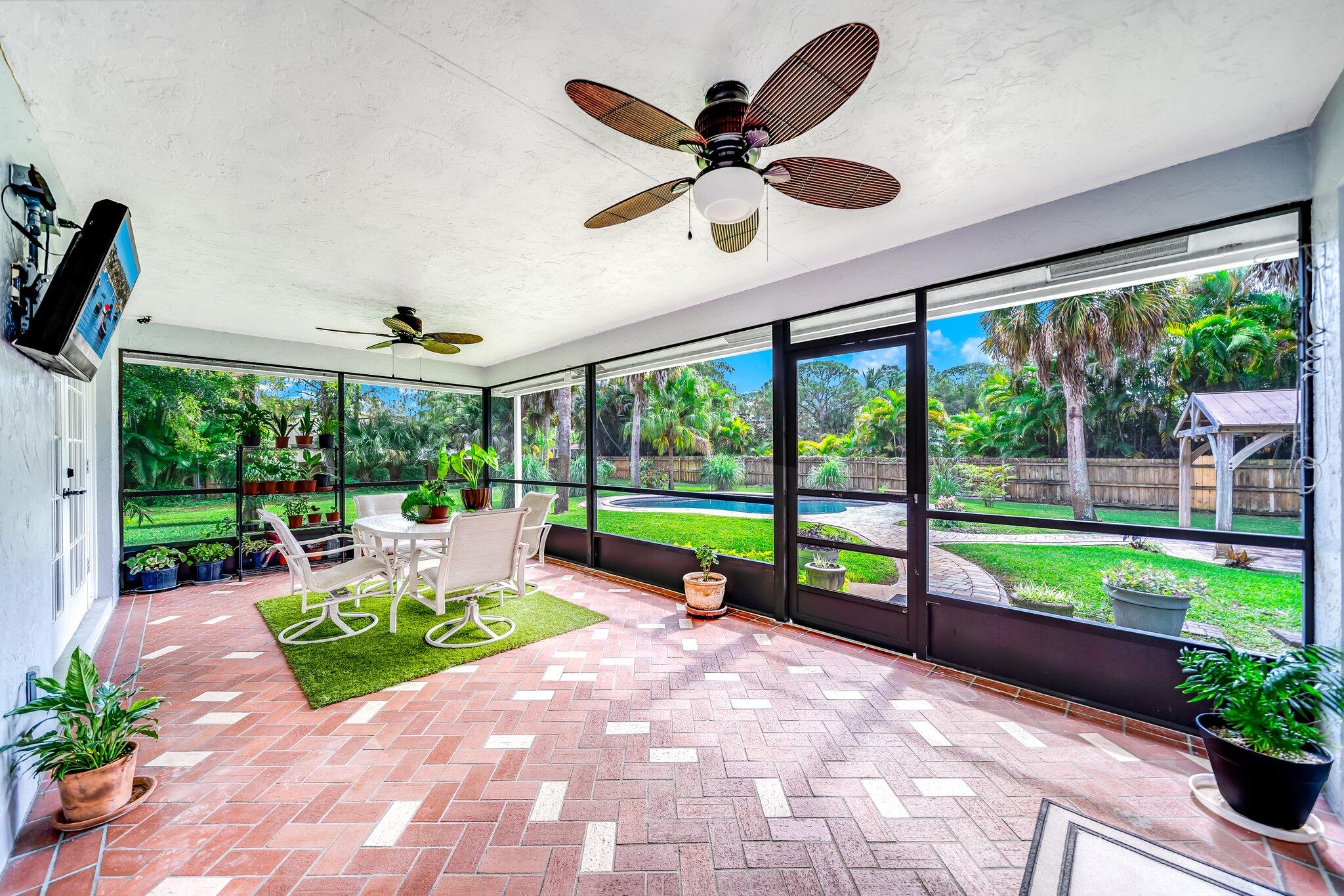 9268 Rodeo Drive Lake Worth, FL 33467 - Photo 37 of 66 a porch with a patio table and chairs