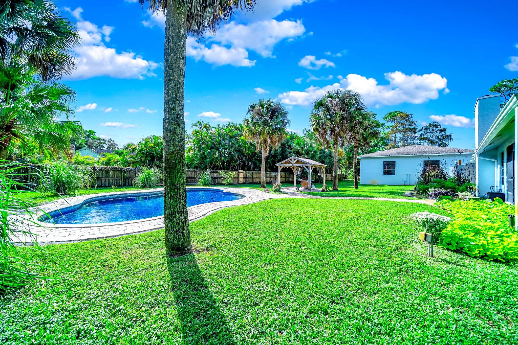 9268 Rodeo Drive Lake Worth, FL 33467 - Photo 44 of 66 a view of a house with a backyard and a fountain