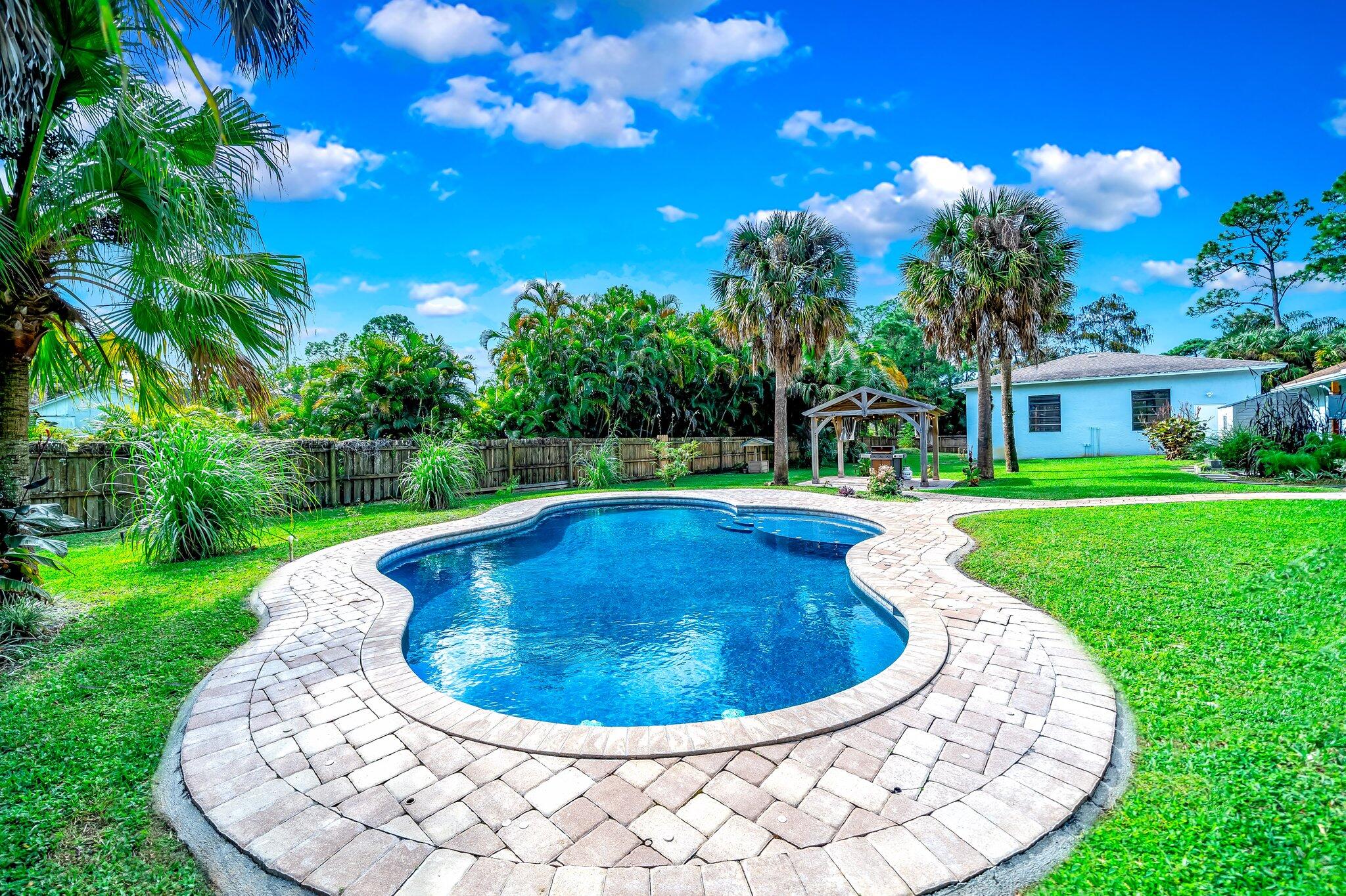 9268 Rodeo Drive Lake Worth, FL 33467 - Photo 48 of 66 a view of a swimming pool with a yard