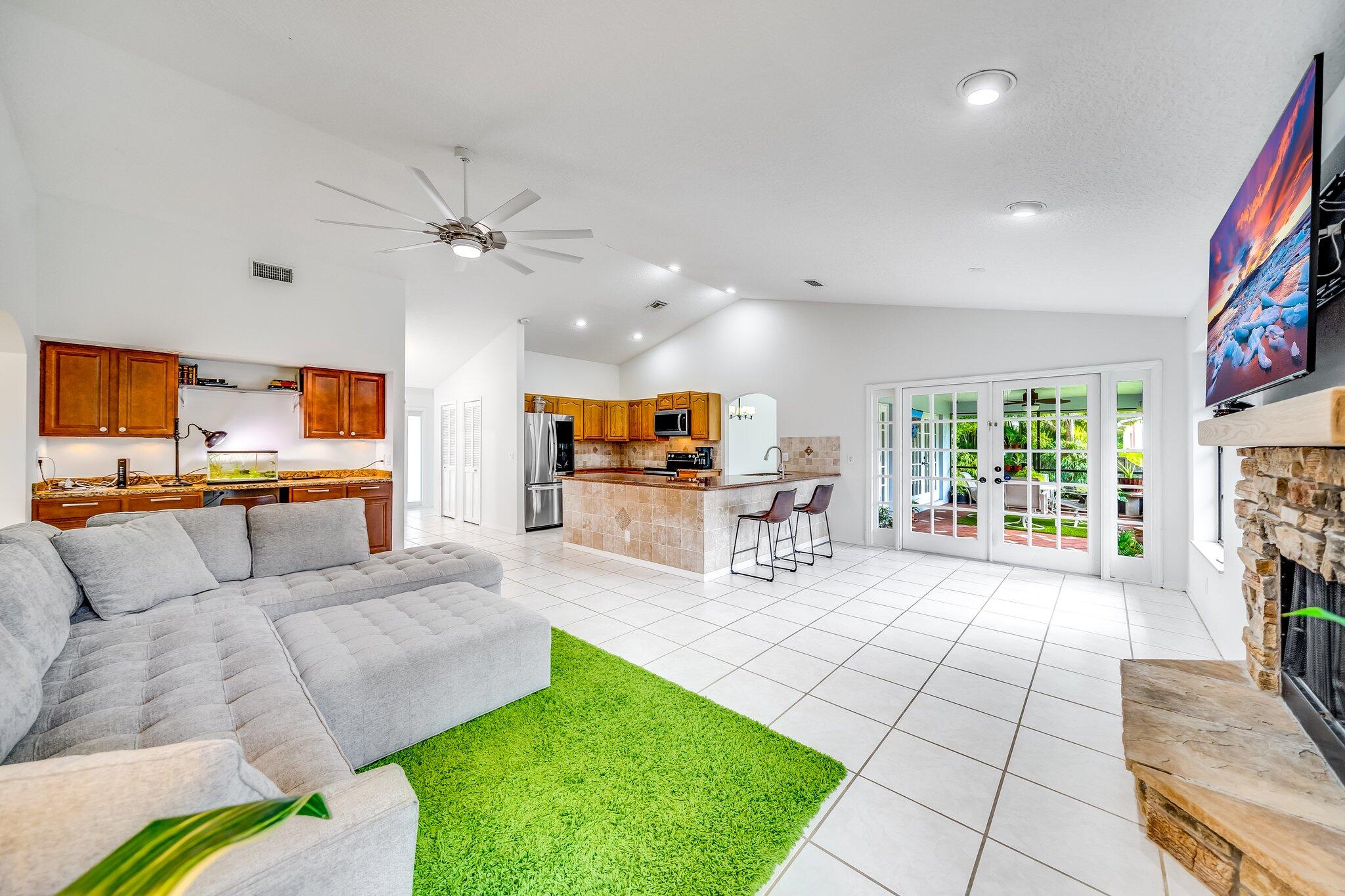 9268 Rodeo Drive Lake Worth, FL 33467 - Photo 8 of 66 a living room with furniture a flat screen tv and a fireplace