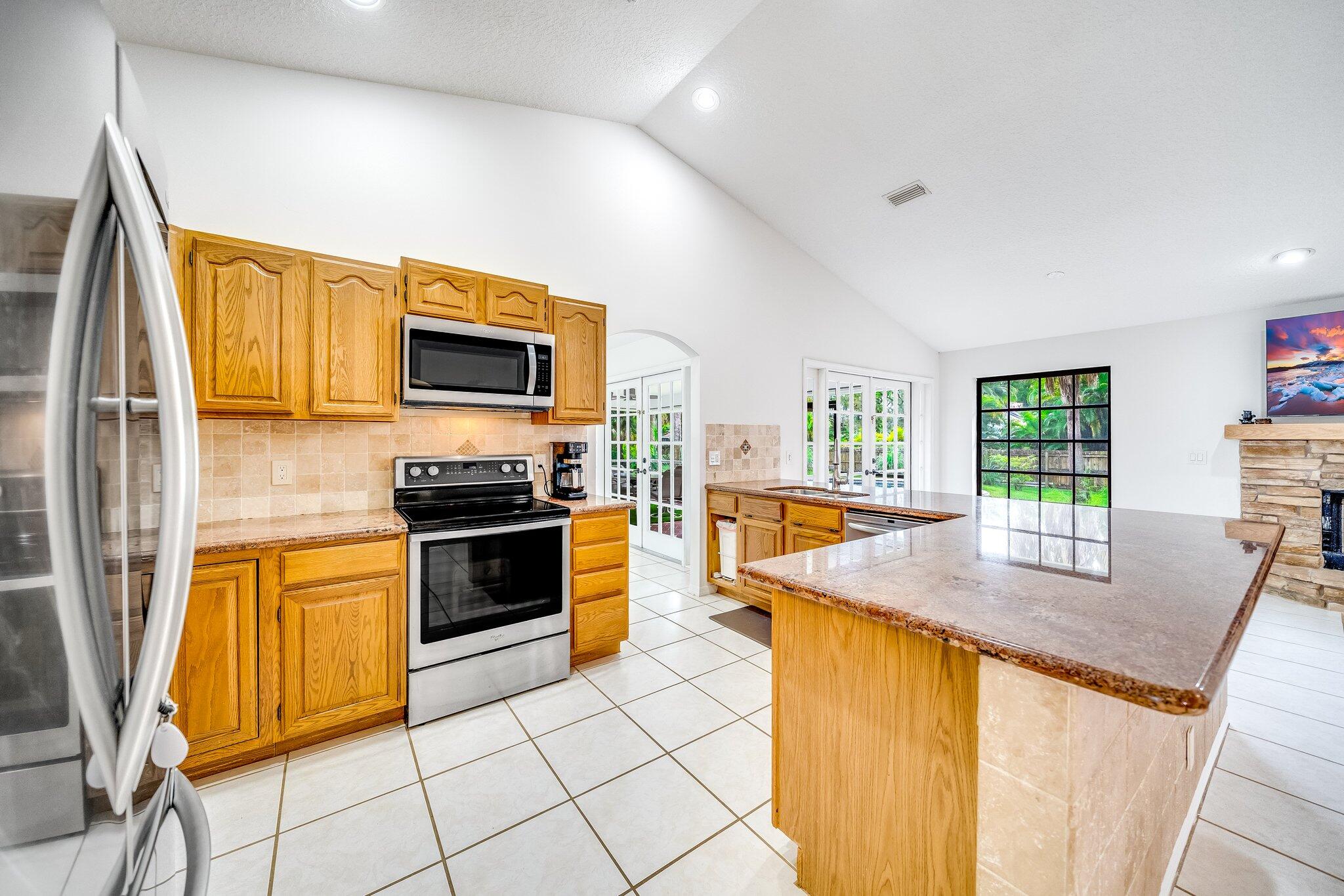 9268 Rodeo Drive Lake Worth, FL 33467 - Photo 10 of 66 a kitchen with granite countertop a stove and a sink