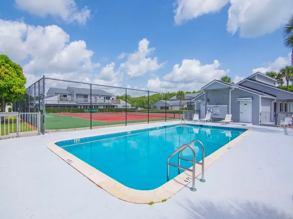 a view of a swimming pool with a lawn chairs under an umbrella