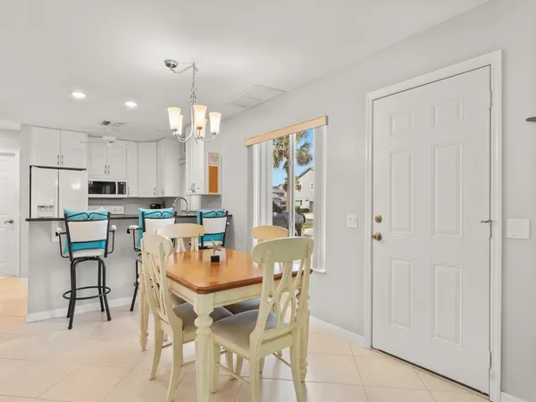 a dining area with stainless steel appliances kitchen island granite countertop a dining table chairs and granite counter tops