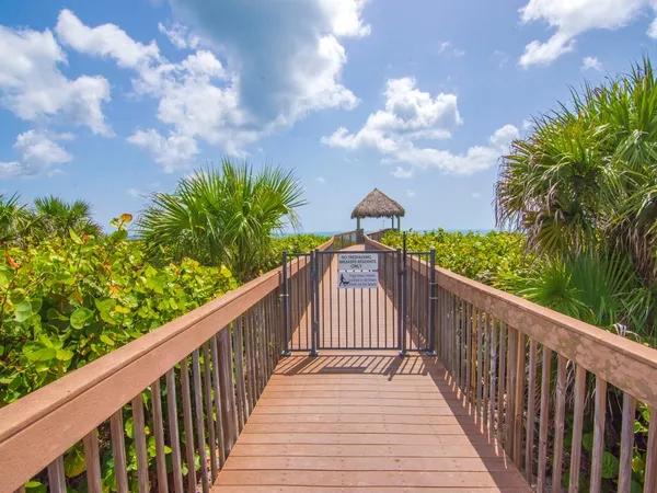 a view of a table and chairs under an umbrella on wooden deck