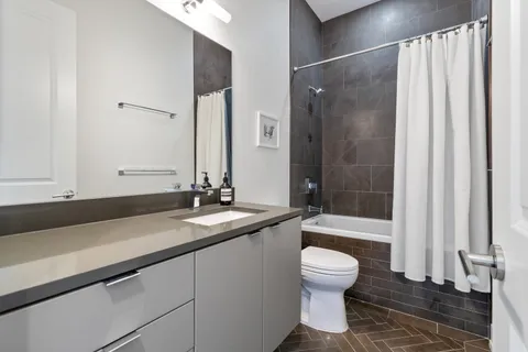 a bathroom with a granite countertop sink toilet a mirror and shower