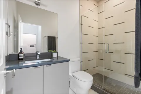 a bathroom with a granite countertop sink toilet and shower