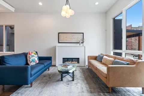 a living room with furniture a fireplace and a large mirror