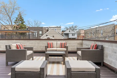 a view of a roof deck with couches and potted plants