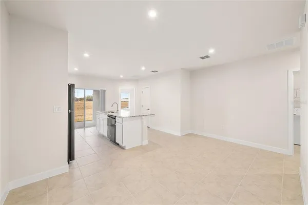 a view of kitchen with refrigerator sink and white cabinets