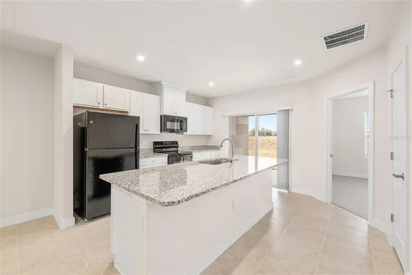 a kitchen with stainless steel appliances a refrigerator and a stove top oven