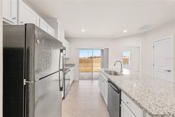 a kitchen with granite countertop a sink and a stove