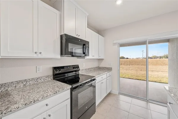 a kitchen with stainless steel appliances granite countertop a sink and a refrigerator