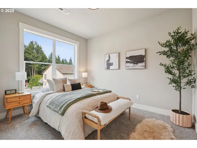 a bedroom with a bed a couch and potted plant