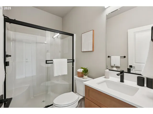 a bathroom with a sink toilet a mirror and shower