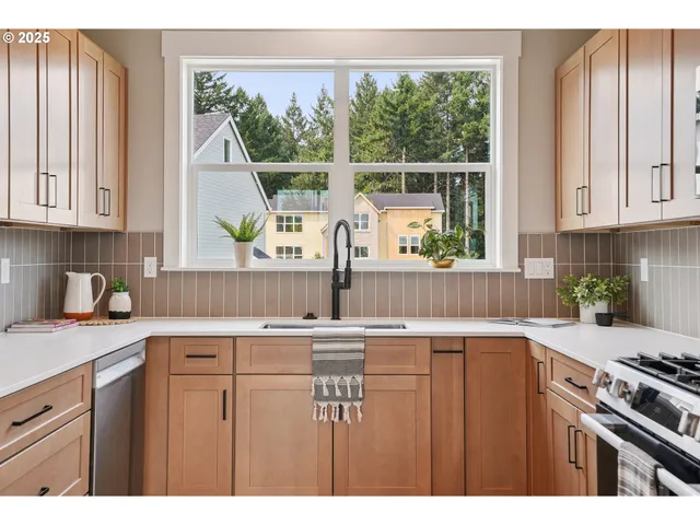 a kitchen with kitchen island a stove a sink and a window