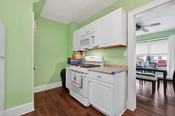 a kitchen with stainless steel appliances granite countertop a stove and a wooden floors