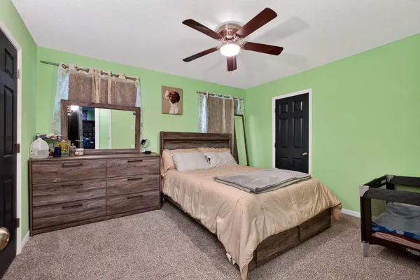 a bedroom with a large bed and a chandelier