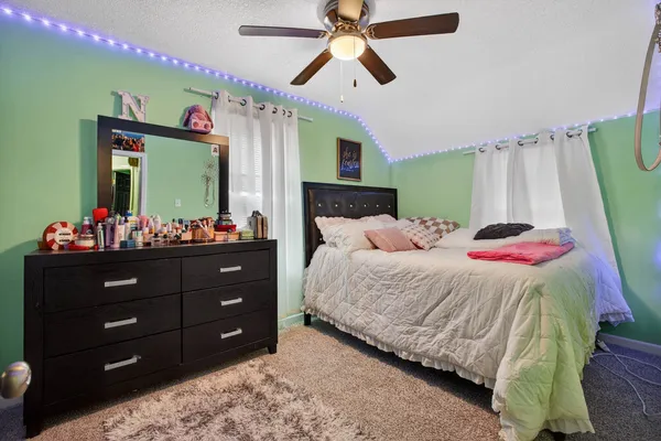 a bedroom with a bed and a mirror on the dresser