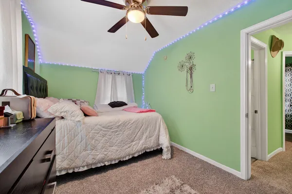 a bed room with a bed mirror and a chandelier