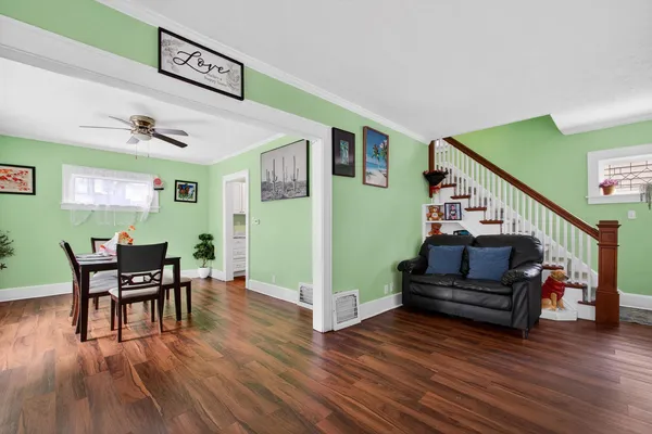 a living room with furniture and a wooden floor