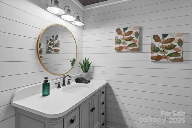 a bathroom with a sink a mirror and painting on the wall