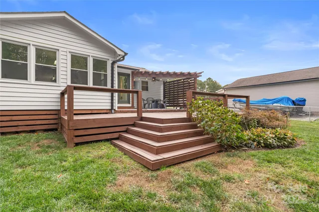 a view of a house with a yard and wooden fence