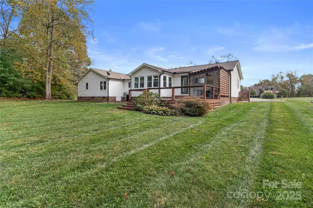 a view of a house with a big yard and large trees