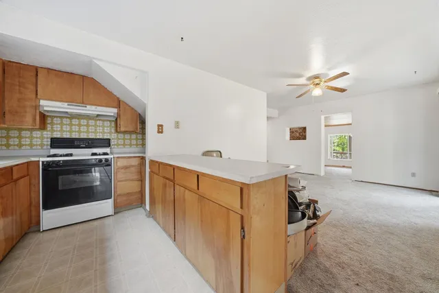 a kitchen with stainless steel appliances a stove a sink and a refrigerator