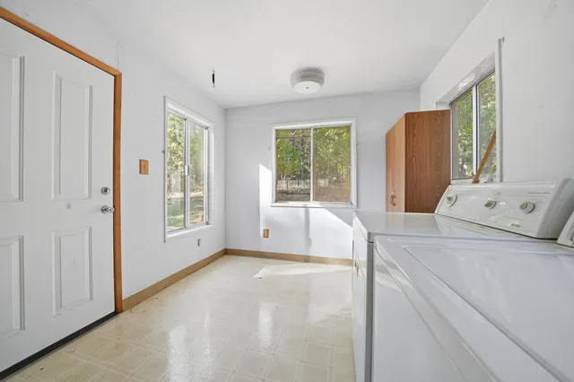 a bed sitting in a spacious bedroom next to a window