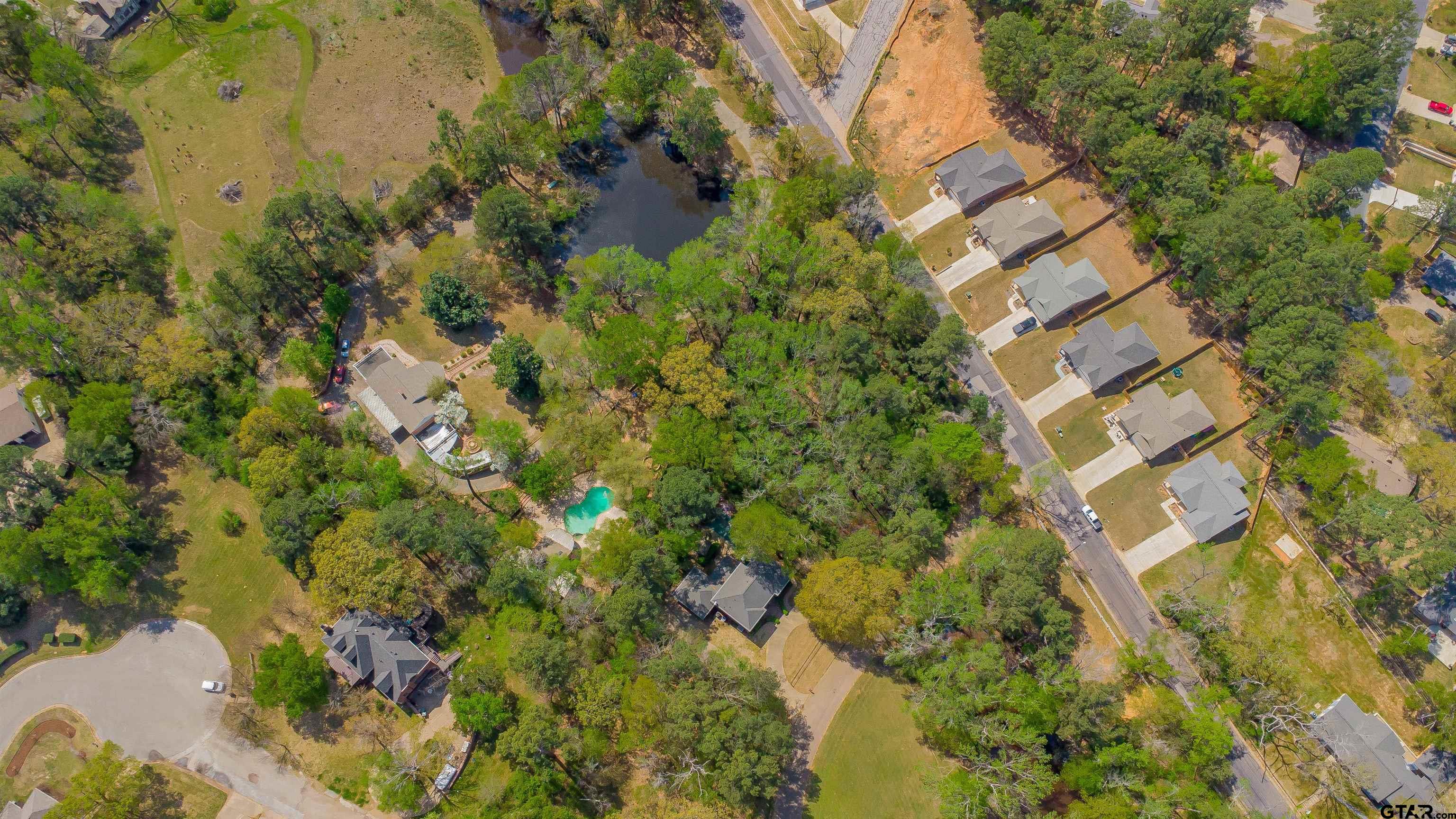 2864 South Robertson Avenue Tyler, TX 75701 - Photo 21 of 39 a backyard of a building with lots of trees