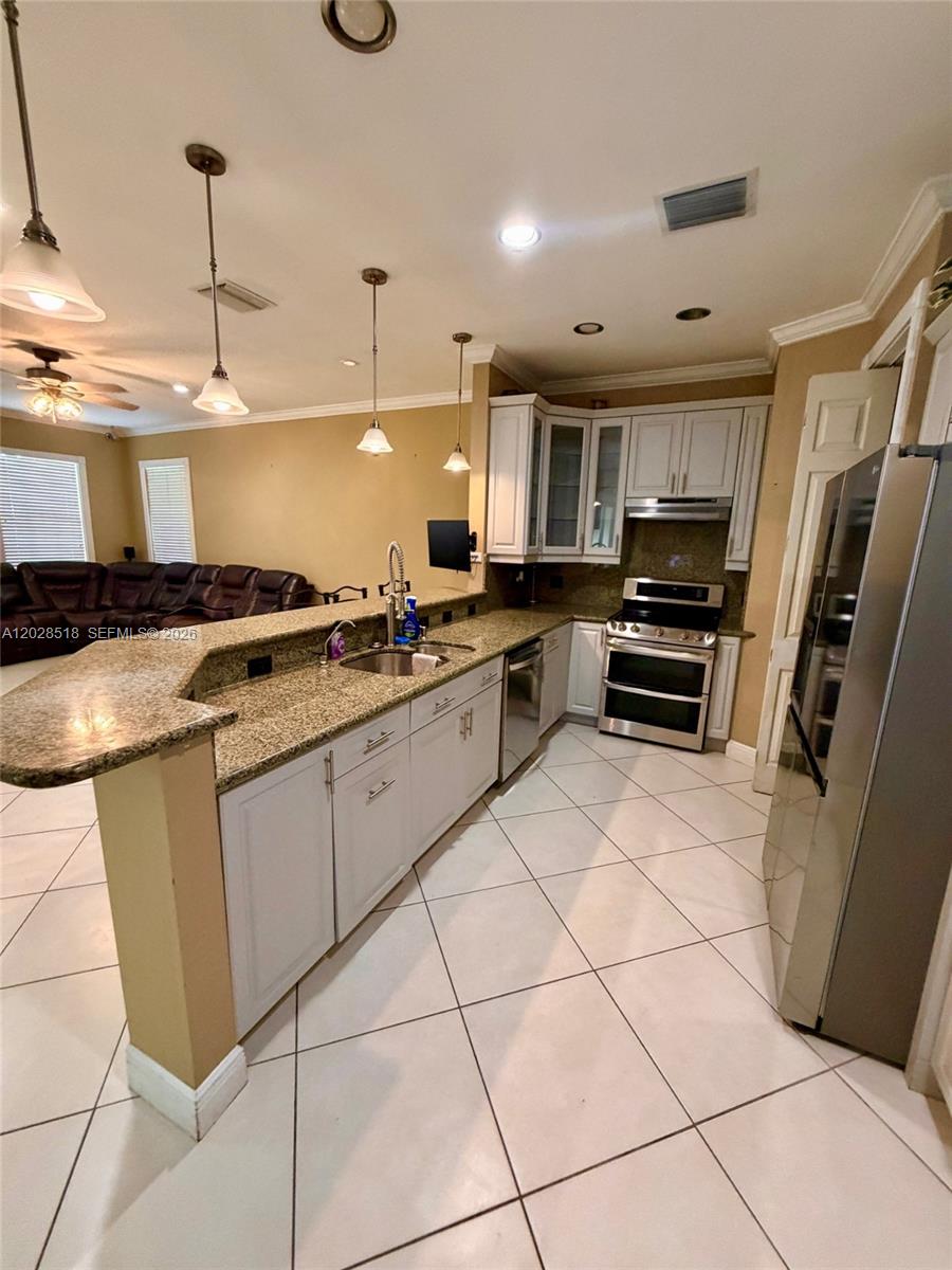 9444 Southwest 78th Street Miami, FL 33173 - Photo 7 of 11 a kitchen with granite countertop a stove a sink and a refrigerator
