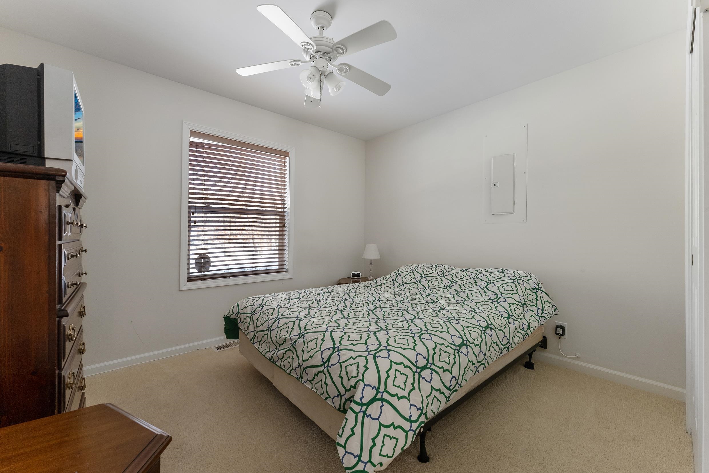204 Tuckahoe Road Marmora, NJ 08223 - Photo 11 of 19 a bedroom with a bed and a chandelier