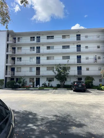 a view of a building with cars parked in front of it