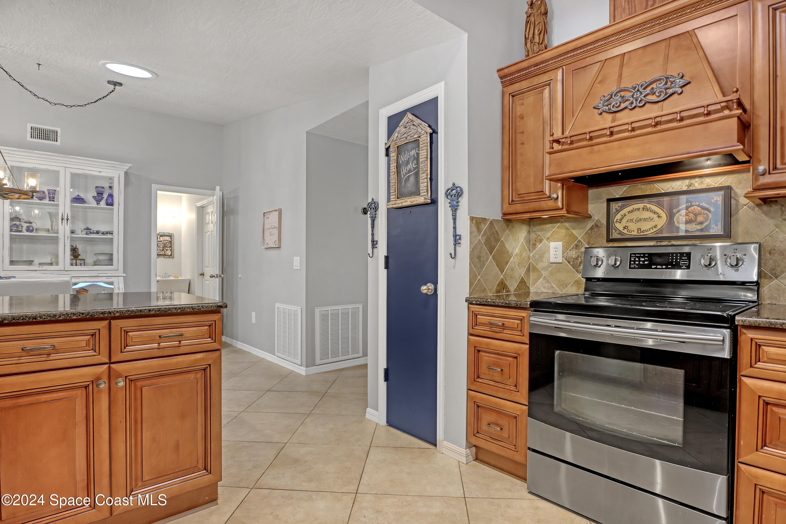 3865 Corey Road Malabar, FL 32950 - Photo 23 of 72 a kitchen with stainless steel appliances granite countertop a stove and a refrigerator