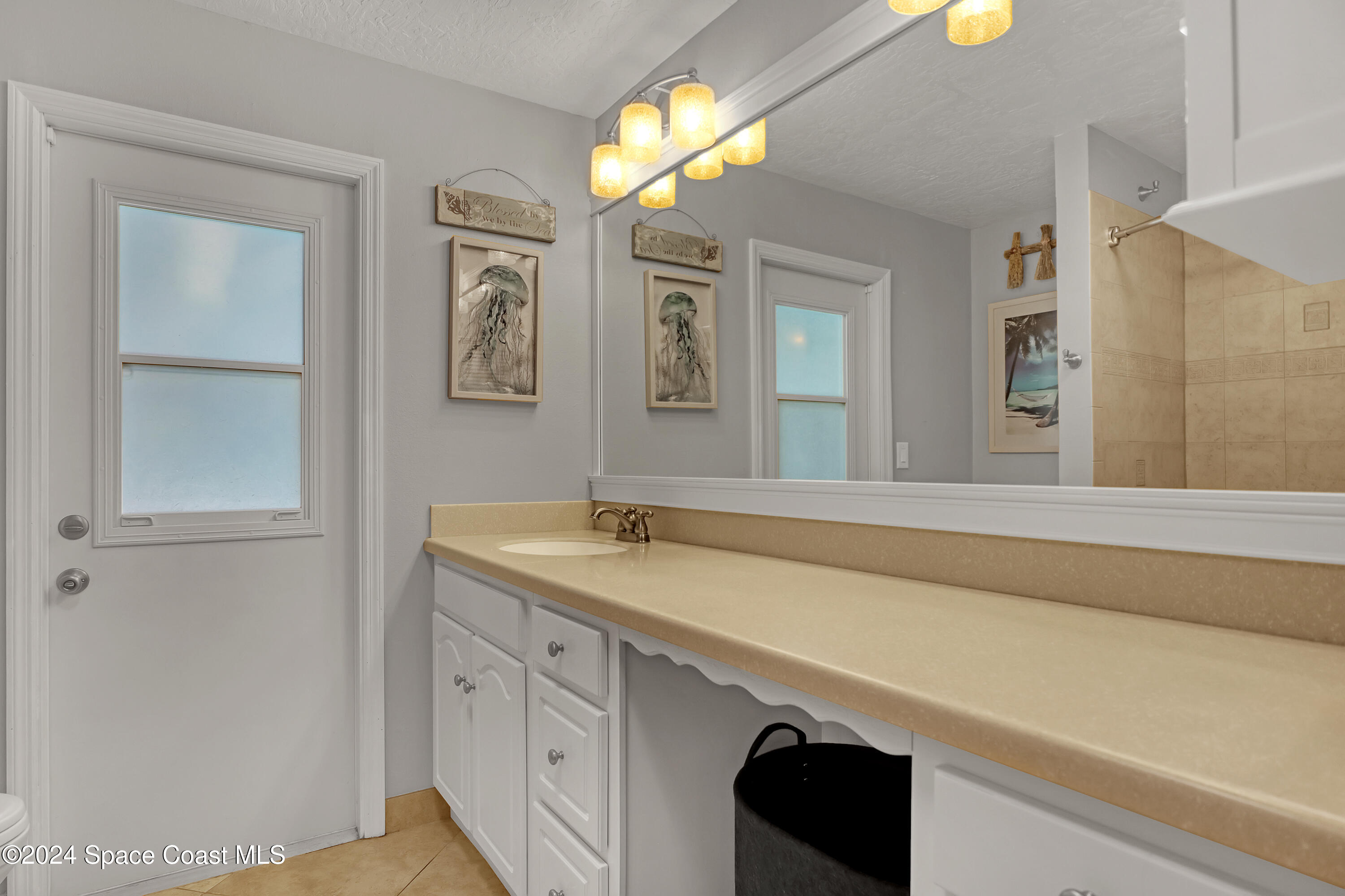 3865 Corey Road Malabar, FL 32950 - Photo 39 of 72 a bathroom with a granite countertop sink a large mirror and a shower