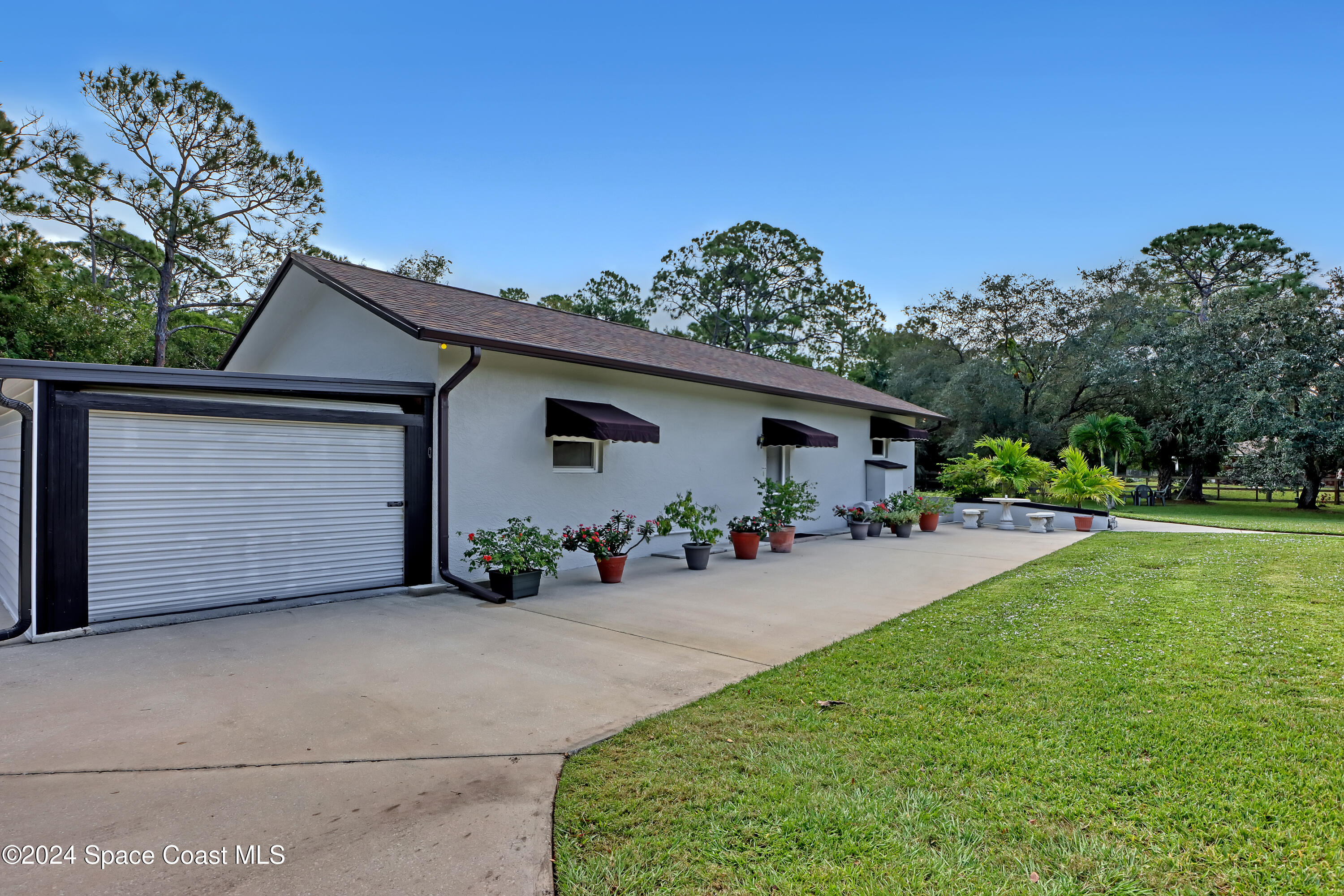3865 Corey Road Malabar, FL 32950 - Photo 50 of 72 front view of a house with a yard and potted plants