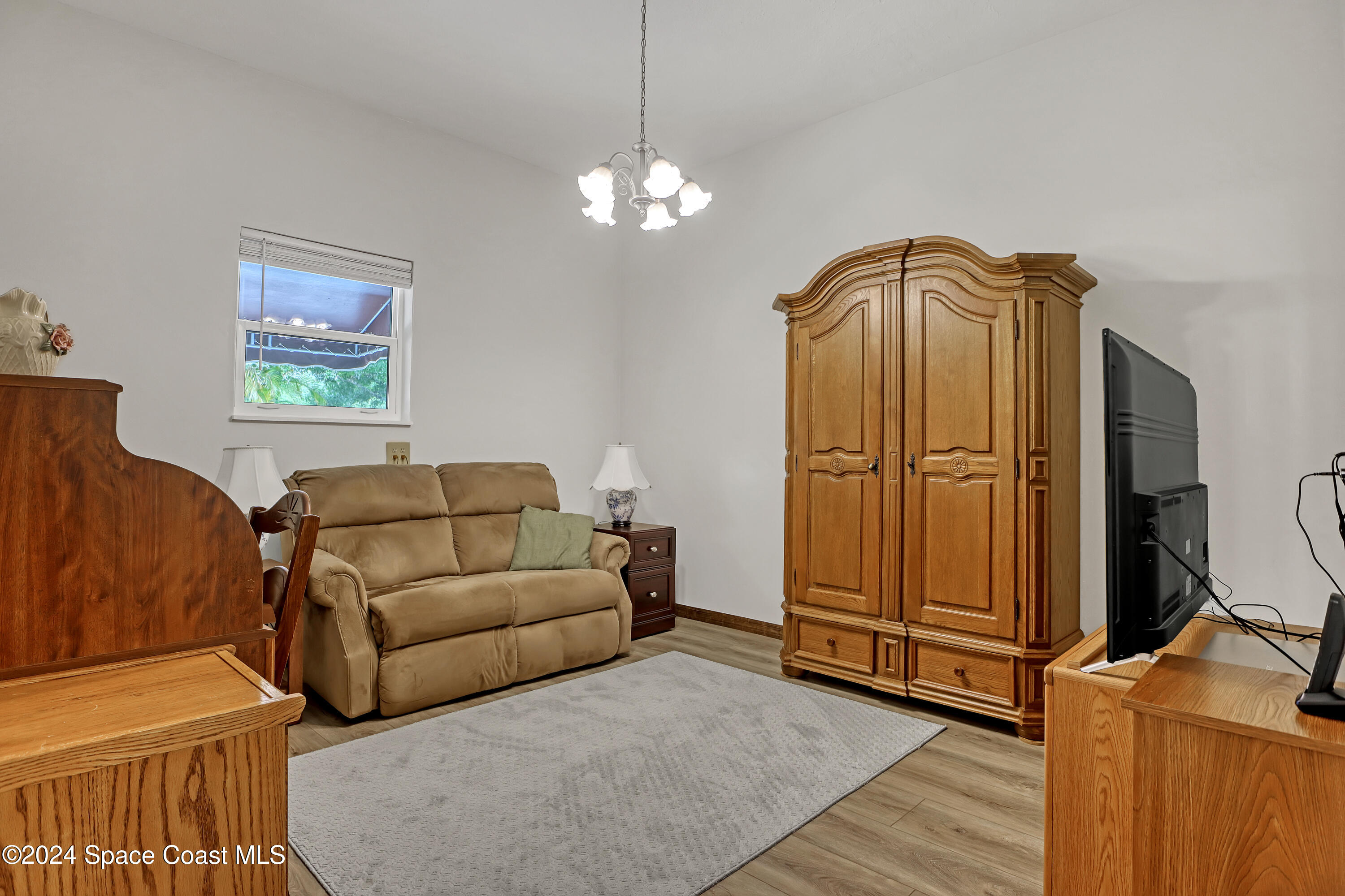 3865 Corey Road Malabar, FL 32950 - Photo 59 of 72 a living room with furniture a chandelier and a window