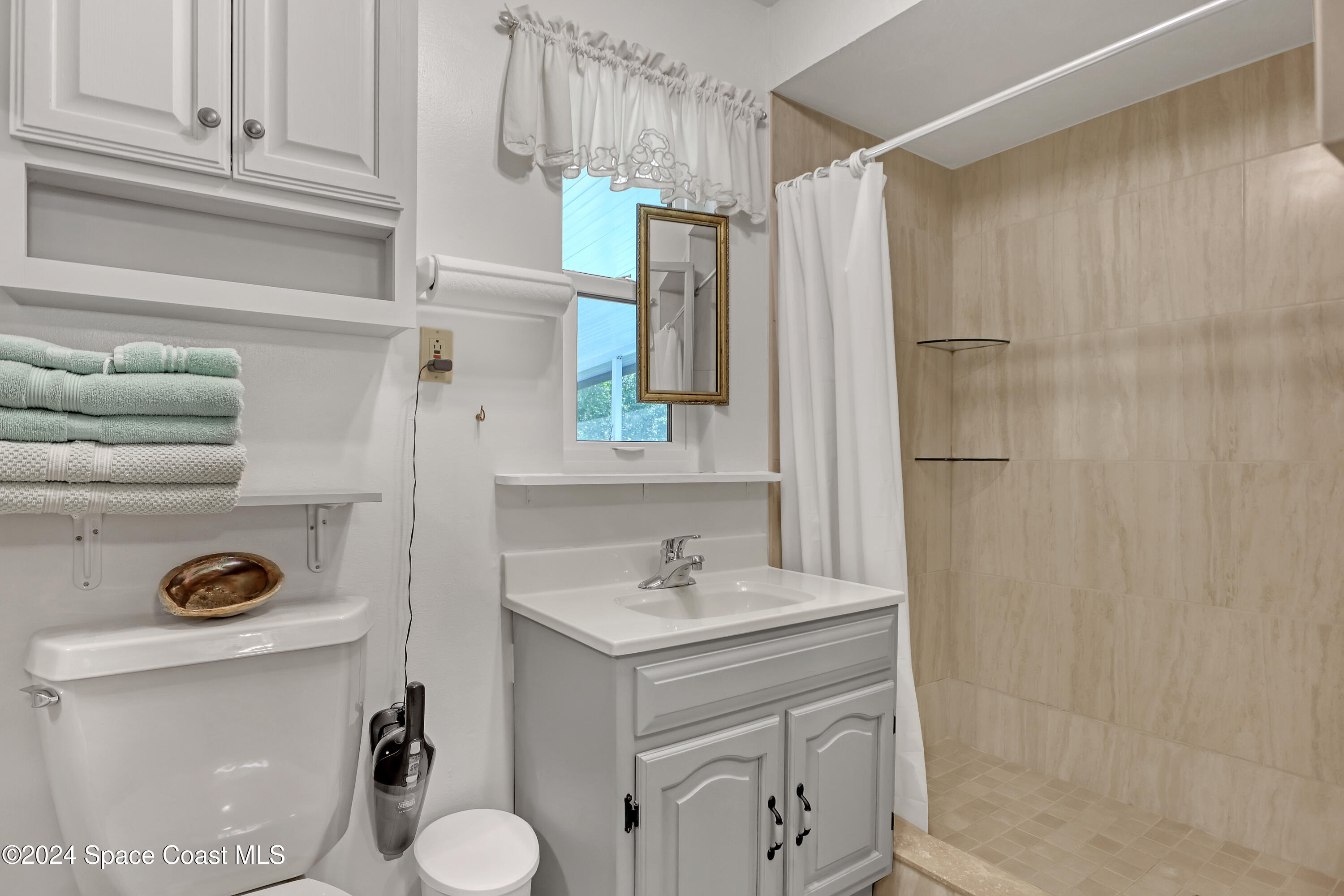 3865 Corey Road Malabar, FL 32950 - Photo 65 of 72 a bathroom with a sink a toilet and shower