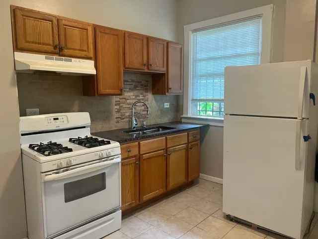 a kitchen with stainless steel appliances granite countertop a refrigerator stove a sink dishwasher and microwave