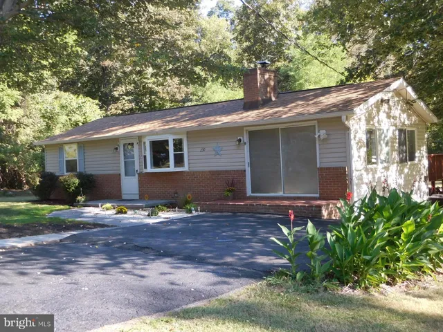 a view of a house with a yard and large tree