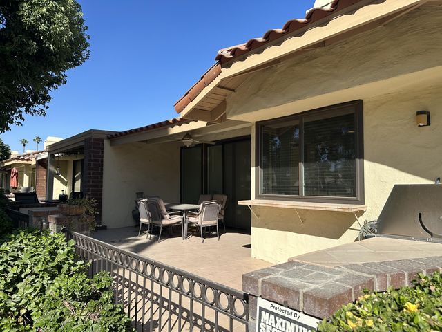 a view of a house with backyard and sitting area