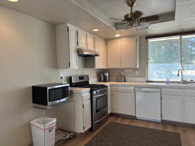 a kitchen with a stove a sink and a microwave